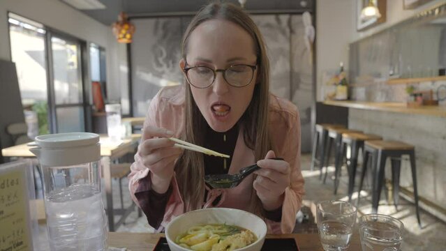 This video shows a woman eating udon ramen.