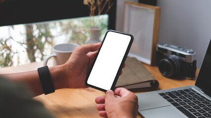View over shoulder of man hands holding smart phone. Empty screen for your advertise text..