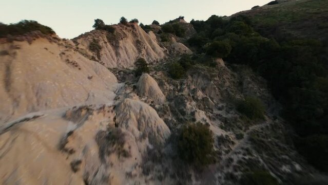 Hilly landscape of Calanchi di Aliano in Italy during sunset. Fast FPV Drone shots