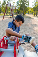 Little boy having fun playing in the playground in a park.