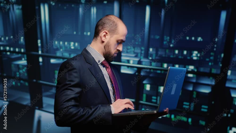 Poster server technician specialist activating hardware server system using laptop, standing in professiona