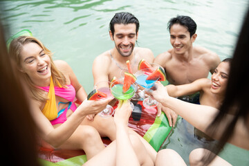 Group of diverse friend drinking alcohol, having a pool party together