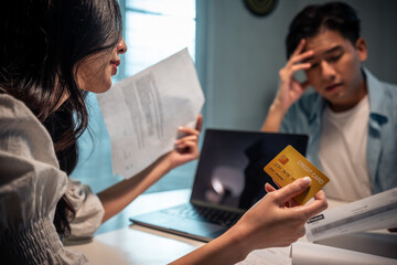 Asian young depressed couple having argument while checking money debt
