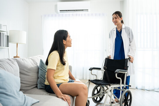 Asian caregiver nurse support female leg amputee sitting on wheelchair