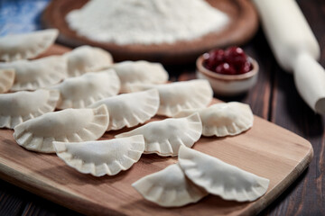 raw dumpling with cherries on the wooden board