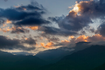 Colourful clouds above Himalayan mountain range after sun has set beyond the mountain peaks. After sun set nature stock image , shot at Okhrey, Sikkim, India.