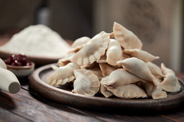 raw dumpling with cherries on the wooden board
