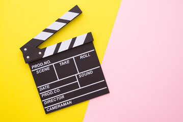Cinema clapperboard on yellow pink colorful background - Movie cinema entertainment concept.