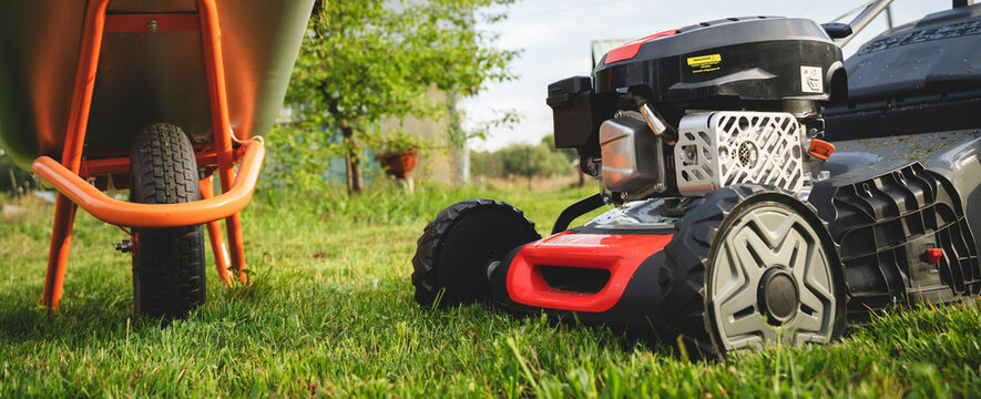 Lawn mover on green grass in modern garden. Machine for cutting lawns.