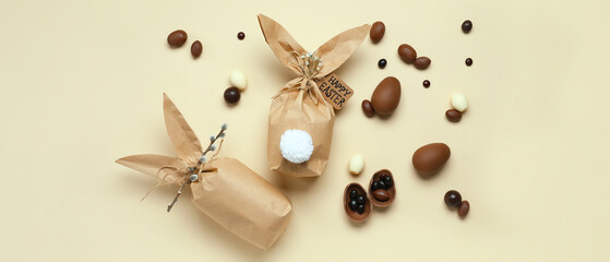 Easter gifts and chocolate eggs on beige background