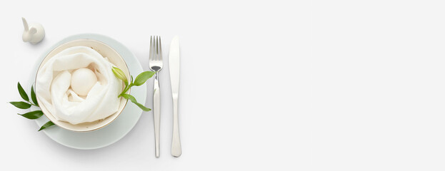Stylish table setting with Easter egg, bunny and plant branches on light background with space for text