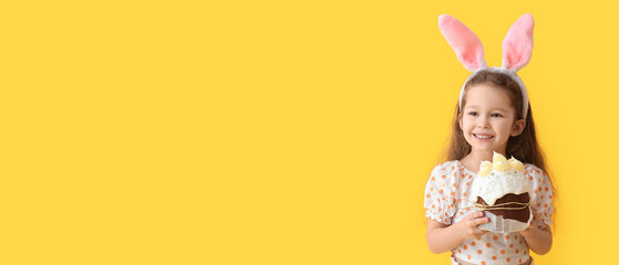 Cute little girl with bunny ears and Easter cake on yellow background with space for text