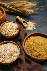 Bowls with cereals on dark background, closeup