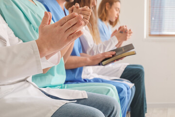 Obraz na płótnie Canvas Group of doctors praying in clinic, closeup