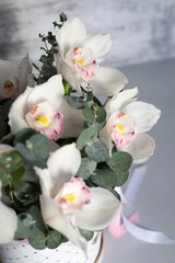 Naklejka na ściany i meble Beautiful luxurious bouquet of orchids and eucalyptus in a box. Professional florist.