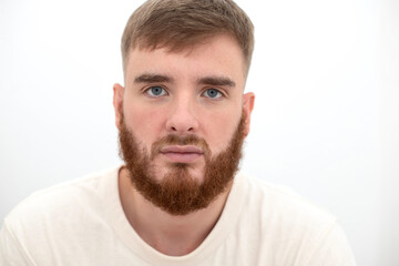 Obraz premium Portrait of bearded happy young handsome man with beard is smiling on white background and looking at camera