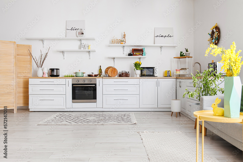 Poster interior of kitchen with easter decor, white counters and shelves