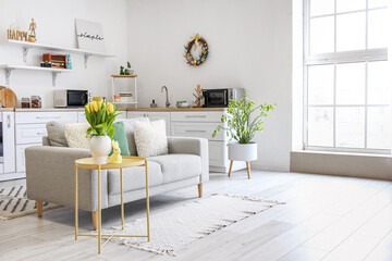 Interior of kitchen with Easter decor, white counters and sofa