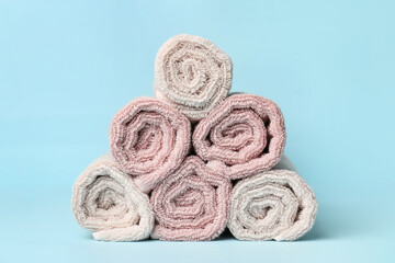 Heap of rolled towels on color background