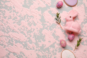 Easter bunny, eucalyptus branches, cookies and painted eggs on pink grunge background