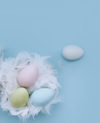 Easter eggs in a nest, turquoise Easter background. Horizontal photo