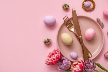 Table serving with Easter eggs and beautiful tulip flowers on pink background