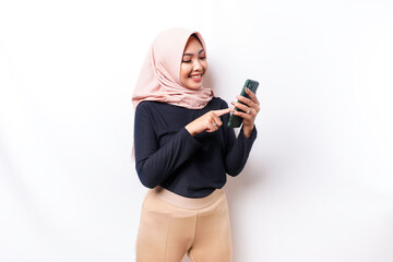 A portrait of a happy Asian Muslim woman wearing a hijab, holding her phone, isolated by white background