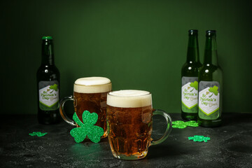 Glasses of beer and paper clovers on dark table. St. Patrick's Day celebration