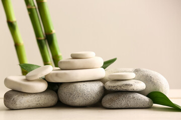 Stack of spa stones and bamboo on light background