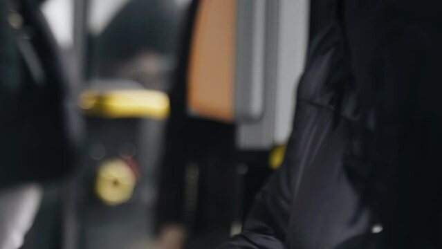 A woman pays for public city transport with a card. Close-up