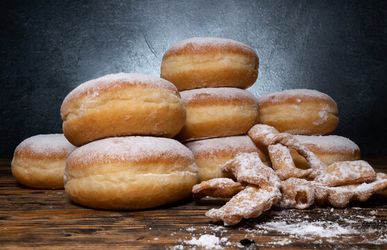 Polish pączki deep-fried doughnuts and angel wings sweet crisp pastry dough, sprinkled with powdered sugar. Popular in Poland during Carnival and Fat Thursday Tłusty czwartek feast day.
