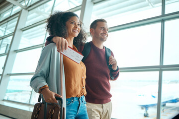 Travel, airport and happy couple with ticket or boarding pass for international flight for holiday...