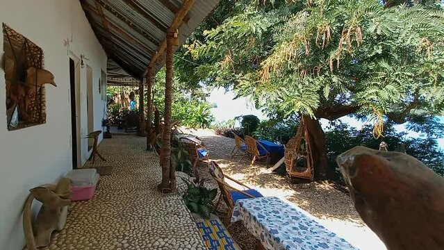 Beautiful African house on the island of Bubaque with wooden chairs under the trees and overlooking the sea