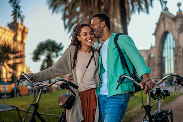 Loving couple with bicycles outside.