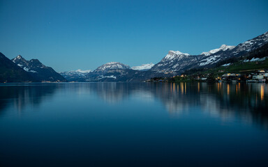 Alpine lake at dusk with Swiss Alps in the background