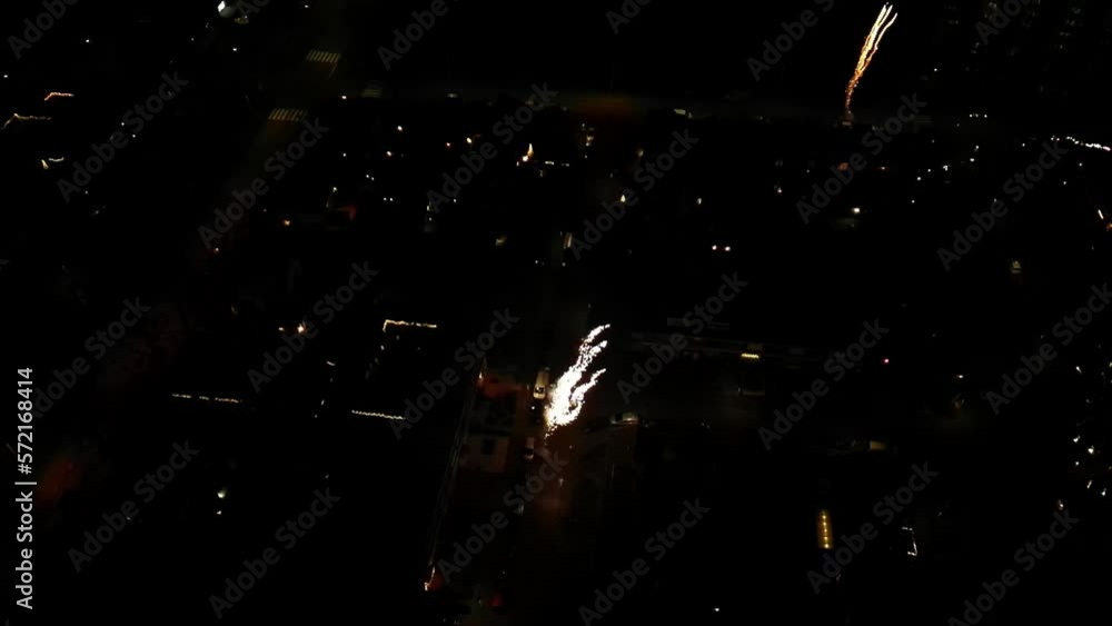 Poster aerial drone view of a city with exploding fireworks in evening sky.