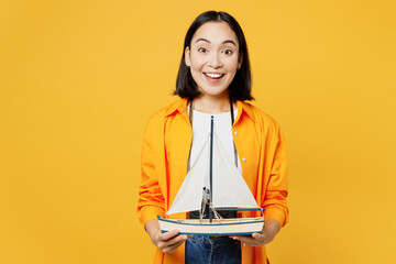 Young excited exultant woman wears summer casual clothes hold ship mockup isolated on plain yellow...