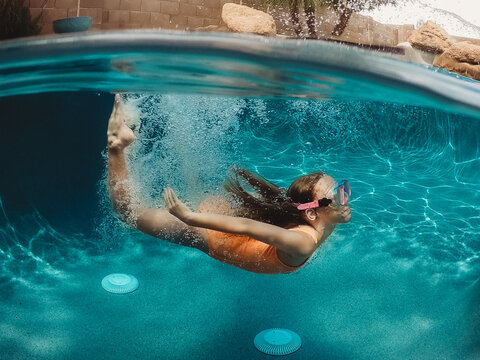 Girl swimming under water in pool
