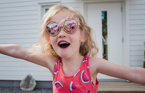 portrait of a young girl with sunglasses on & a reflection of her mom