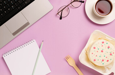 Office desk with notepad computer supplies cup of coffee bento cake. Holiday in workplace, recycling