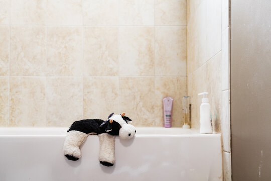 Stuffed animal toy cow on bathtub