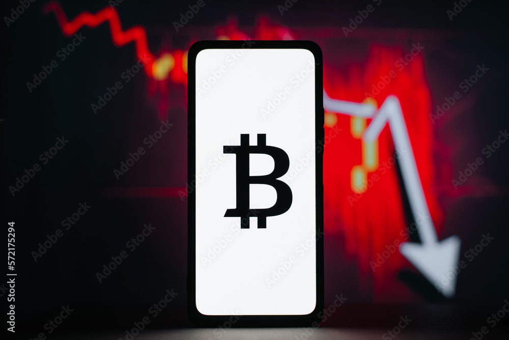 Poster bitcoin icon on smartphone against background of red down arrow and stock chart. stock price fall, s