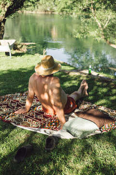 A man sitting on the colorful rug in nature enyojing the view