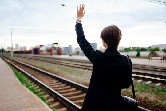 Woman waving hand leaving train