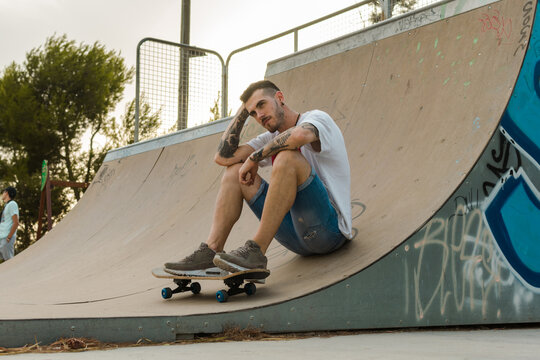 Young man is on a skate court with his skateboard