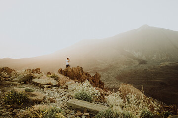 Pulled back view of man taking a photo with Teide in background