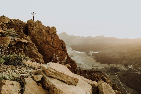 Pulled back view of man standing on mountain top at Cañadas del Teide