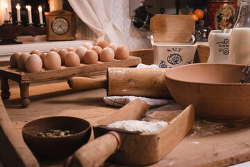 Baking christmasbuns in a country kitchen, eggs, milk, flour, salt, sugar standing on an old baking table
