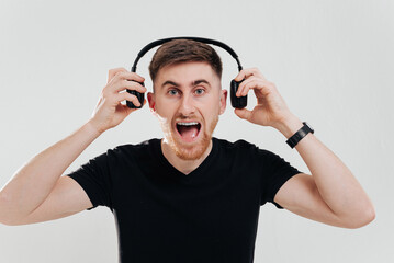 Happy man smiling listening to music in headphones. White background.