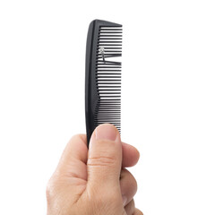 Lifehack; Use a comb to nail things and protect fingers. Male hand holding a black comb to nail things and protect fingers isolated on white background    